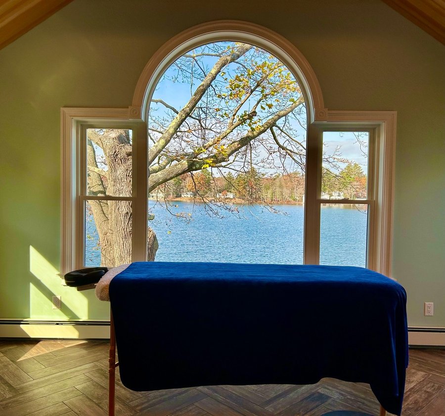 Reiki treatment table with arched window and lake view